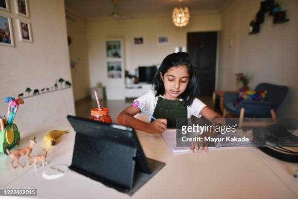 young girl attending online school - young girls homework stockfoto's en -beelden