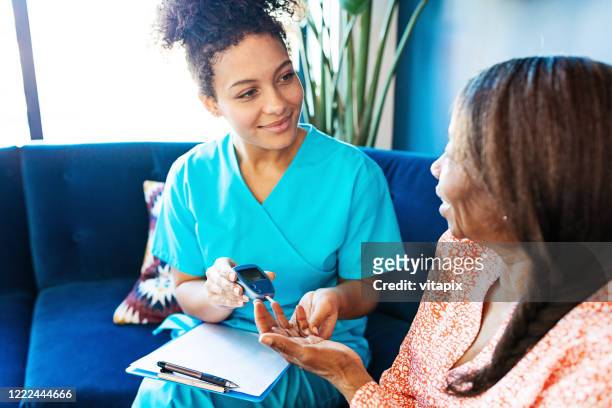 nurse visiting her senior patient - diabetes care stock pictures, royalty-free photos & images