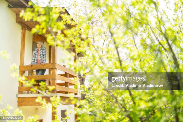 frau verbringt freizeit auf dem balkon - müde frühling stock-fotos und bilder