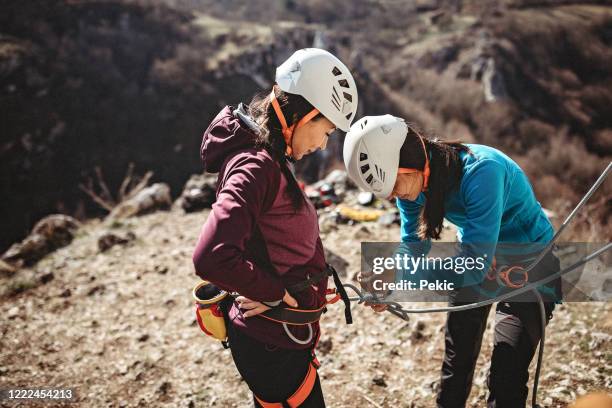 überprüfung der sicherheitsstufen für ein klettern im freien - woman climbing rope stock-fotos und bilder