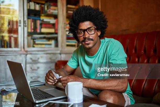 mid adult afro-caribbean man managing home finances - coffee moustache stock pictures, royalty-free photos & images