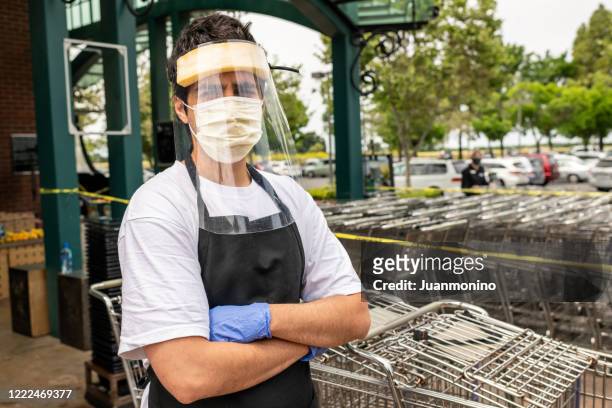 supermarkt-mitarbeiter trägt masken und latexhandschuhe durch ansteckungsprävention - essenzielle berufe und dienstleistungen stock-fotos und bilder