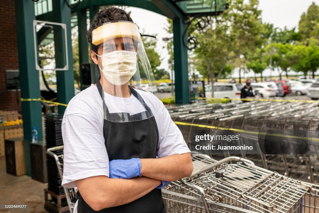 Supermarket employee wearing masks and latex gloves due contagion prevention