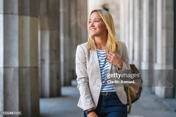 cheerful female law student walking in university colonnade - law student stock pictures, royalty-free photos & images