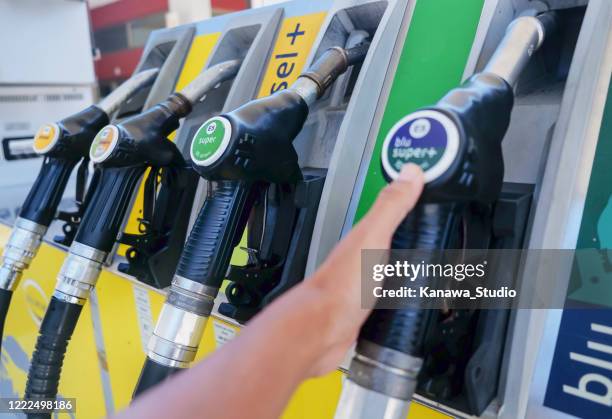 self-service at gas stations amid coronavirus pandemic - working oil pumps stock pictures, royalty-free photos & images