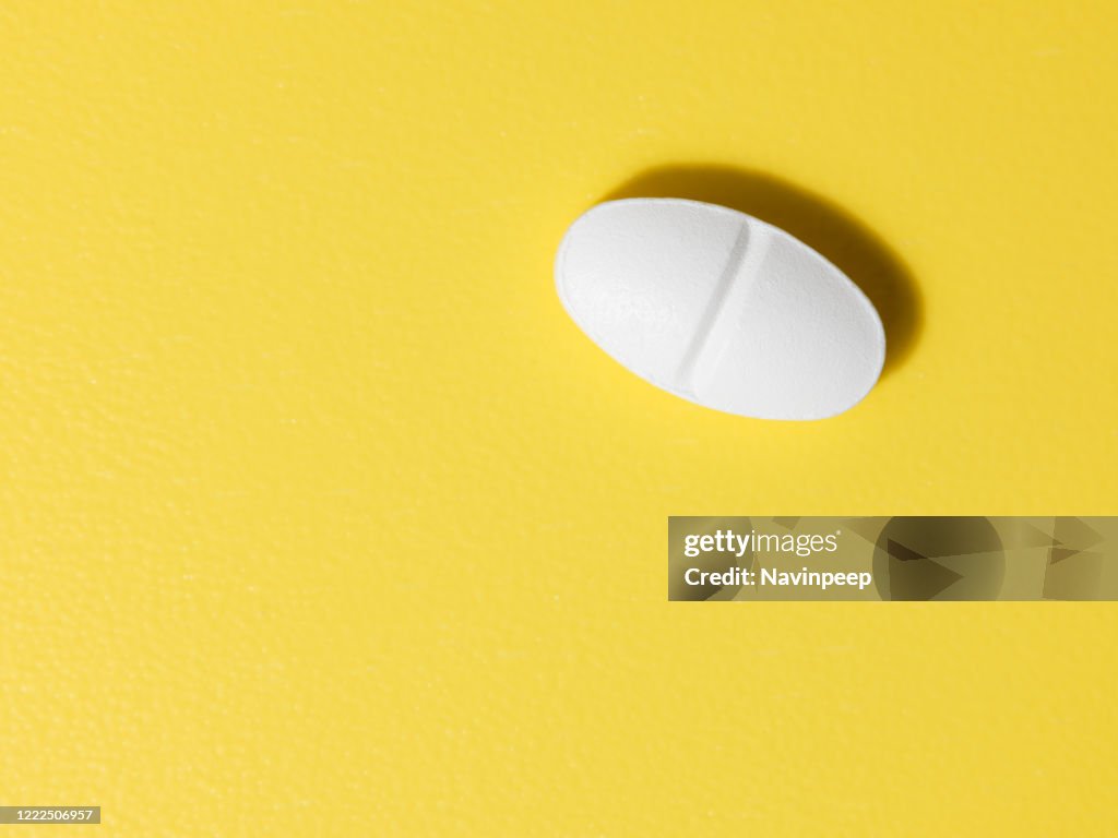 Oval white pill on yellow background