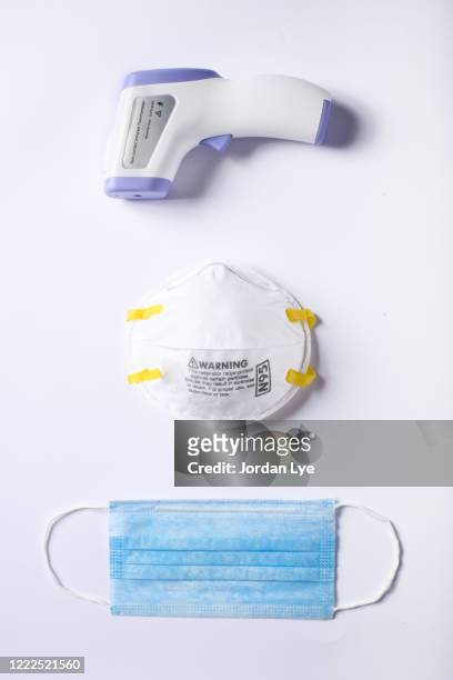 flat lay of n95, surgical mask and infrared thermometer - surgical mask stock-fotos und bilder