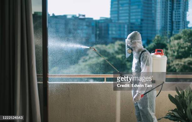 oneman in protective suit spraying the house and disinfecting the housing exterminator pest control virus - pest control equipment stock pictures, royalty-free photos & images