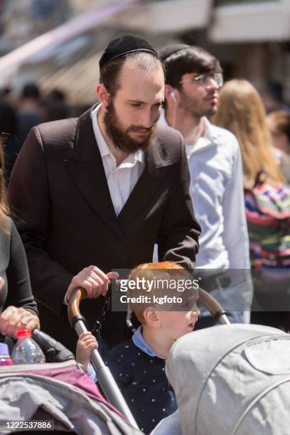 vater schiebt kinderwagen mit seinem rotschopf sohn in jerusalem altstadt, israel - hasidic jews stock-fotos und bilder