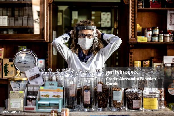 Assunta owner of the herbalist's shop Il Germoglio is portrayed while adjusting her protective gear against Covid-19 on May 2, 2020 in Rome, Italy....