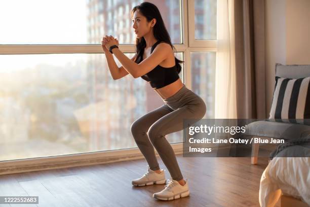 young chinese woman exercising at home - agachar se imagens e fotografias de stock