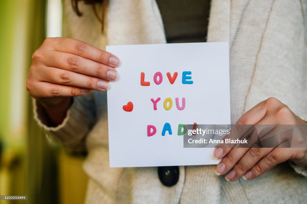 Greeting Card for Happy Father's Day, on the bed, paper white sheet with text Love You Dad and heart, colorful letters