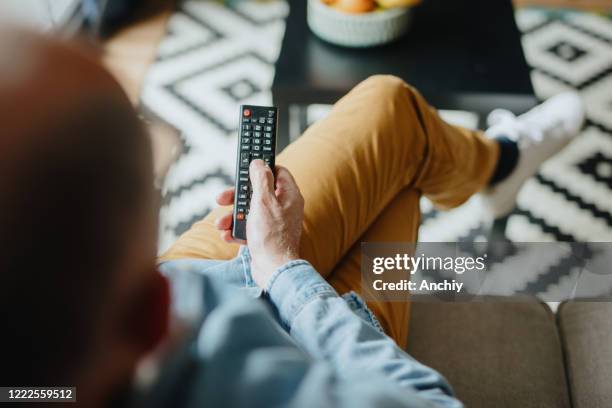 senior man watching tv at home - changing channels stock pictures, royalty-free photos & images