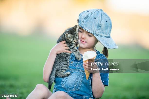young child enjoys ice cream - girl eating messy ice cream cone stock pictures, royalty-free photos & images