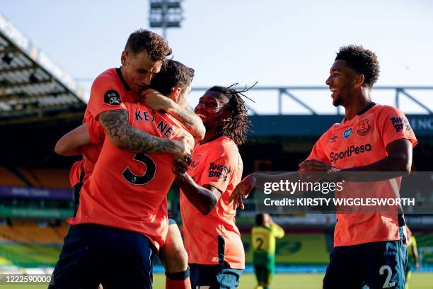 Everton's English defender Michael Keane celebrates with teammates after scoring the opening goal during the English Premier League football match...