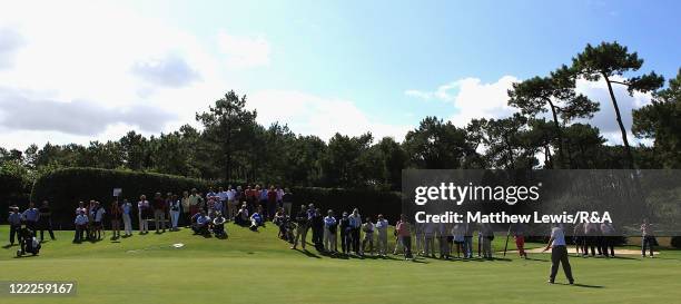 Dermot McElroy of Great Britain and Ireland makes a putt on the 18th green during their Foursome match against Goncalo Pinto and Javier Sainz of the...