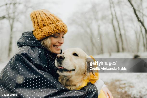 smiling woman and her dog in a snowy day - winter health imagens e fotografias de stock