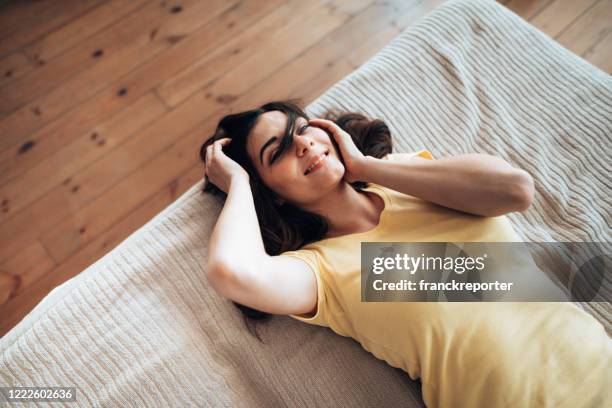 frau liegt glück auf dem bett liegend - cooling down stock-fotos und bilder