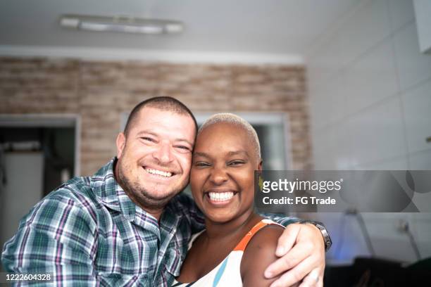 portrait of couple smiling inside the house - generation x stock pictures, royalty-free photos & images