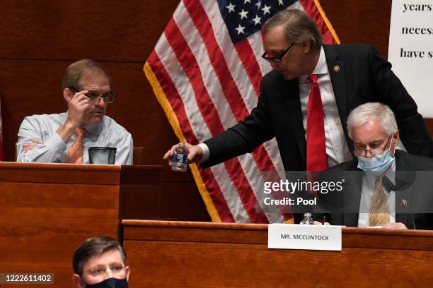 Rep. Andy Biggs second from right, talks with Rep. Jim Jordan , left, during a House Judiciary Committee hearing on oversight of the Justice...