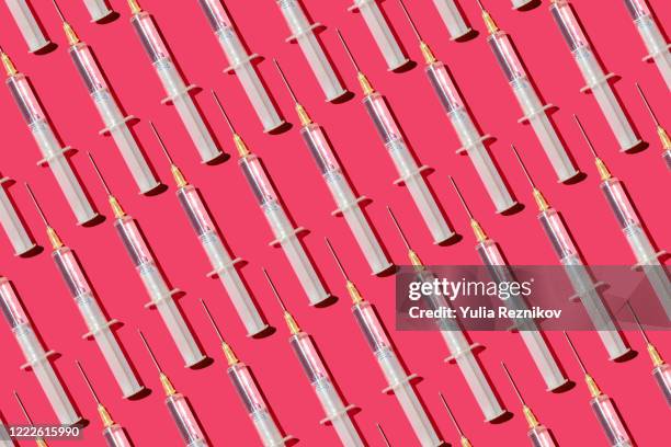 repeated syringes on the pink background - studio shot stock-fotos und bilder