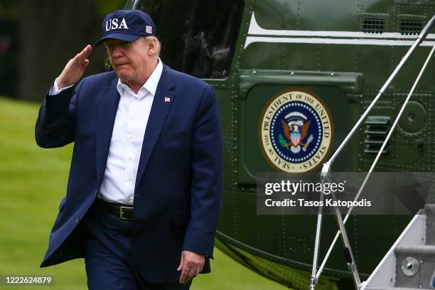President Donald Trump salutes after getting off Marine One on the south lawn of the White House, after after spending the weekend at Camp David on...
