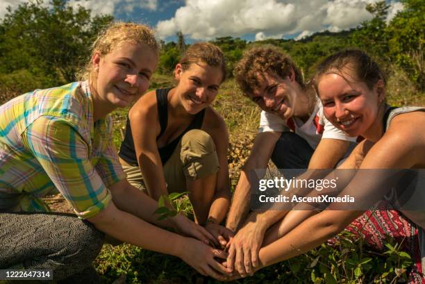 group of young farmers join hands - gap year stock pictures, royalty-free photos & images