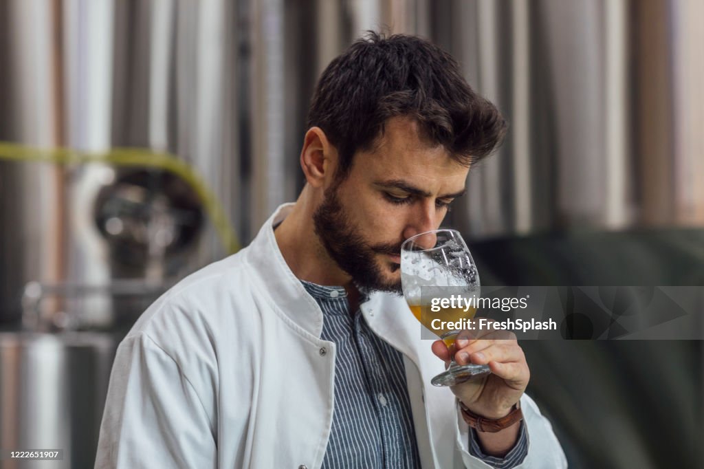 Qualitätskontrolle in einer Craft-Brauerei: Ingenieur prüft den Biergeruch