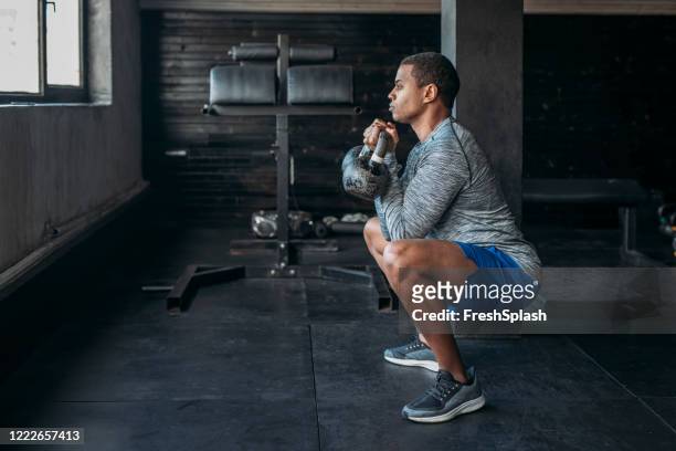 deportista levantando pesas en un gimnasio crossfit - hombre agachado fotografías e imágenes de stock