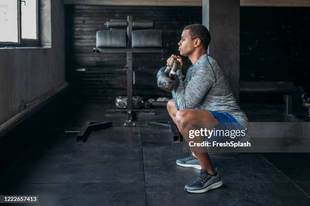 esportista levantando pesos em uma academia de crossfit - squatting position - fotografias e filmes do acervo