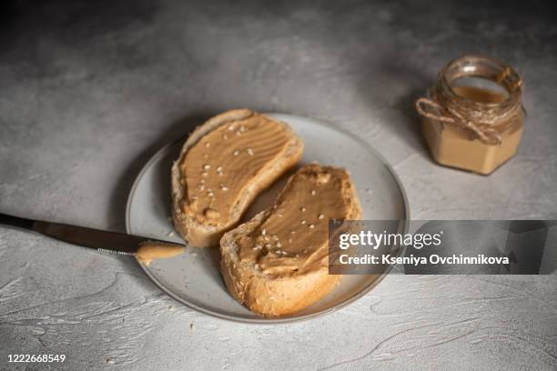 peanut butter sandwiches or toasts on light wooden background - peanut butter and jelly sandwich on plate stock pictures, royalty-free photos & images