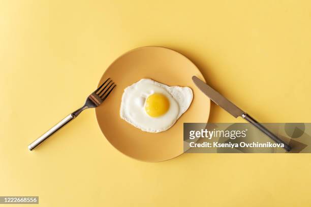 fried egg on yellow background, top view - animal egg stock pictures, royalty-free photos & images