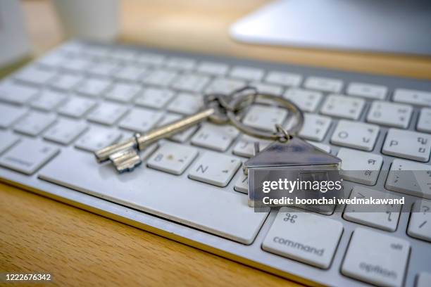 mortgage concept with key and house-shaped keyring on laptop keyboard. - rent assistance stock pictures, royalty-free photos & images