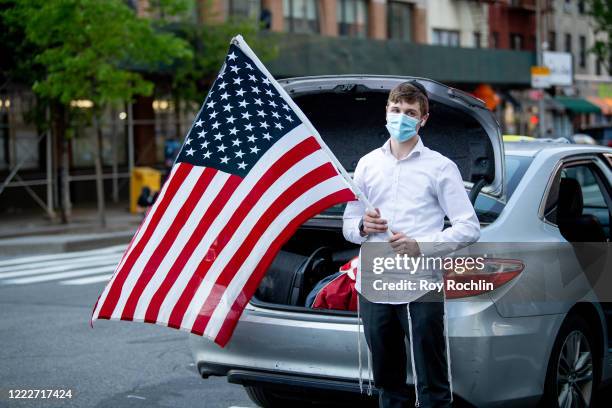 Member of the Hassidic Jewish community holds an American flag as residents greet and clap for medical and front line workers at the 30th Street NYU...