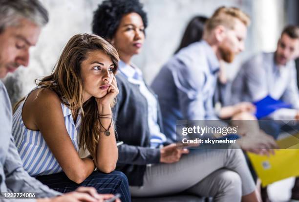 jonge onderneemster die bored voelt terwijl het wachten op baangesprek. - ongeduldig stockfoto's en -beelden