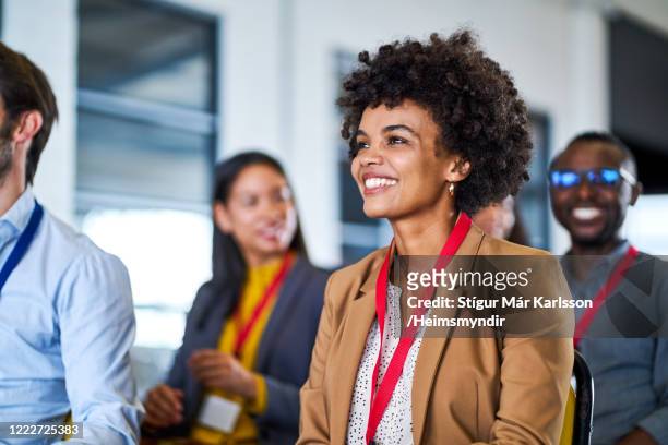 zakenvrouwen met krullend haar in globale conferentie - lanyard stockfoto's en -beelden