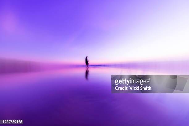 purple swirling pattern with the shape of a person in the center taken at sunrise - farbe ändern stock-fotos und bilder