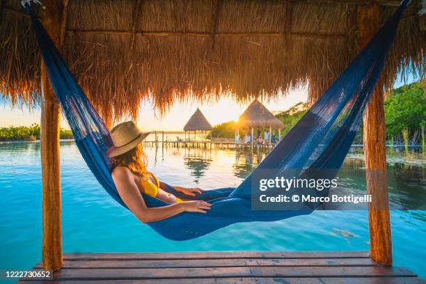 woman relaxing on a hammock under a palapa, mexico - exoticism 個照片及圖片檔