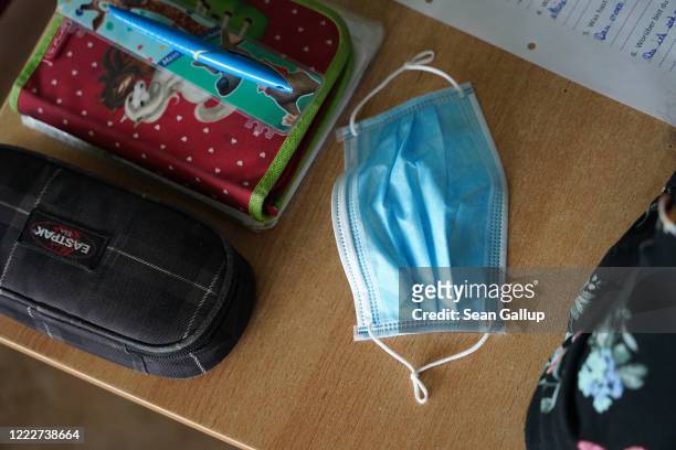 Surgical mask lies on a sixth grader's desk on the first day of classes since March at the GutsMuths Grundschule elementary school during the novel...