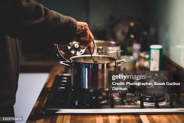 a man preparing dinner - man cooking pan stock pictures, royalty-free photos & images