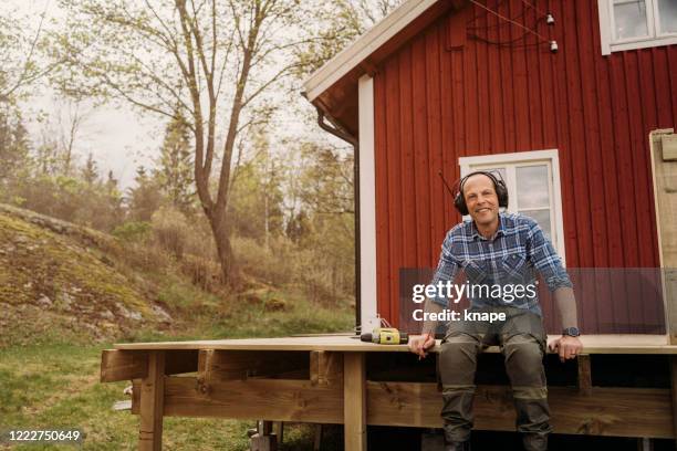 man building a wooden patio deck outdoors in his garden - real life stock pictures, royalty-free photos & images