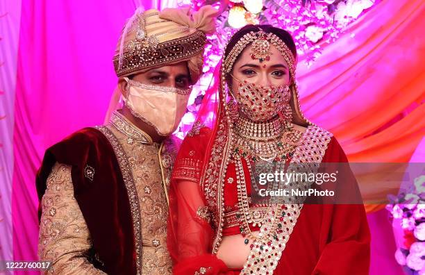 Indian Bride and groom wear masks during their wedding in Tonk, Rajasthan, India on 24 June 2020. According to state government guidelines, a maximum...