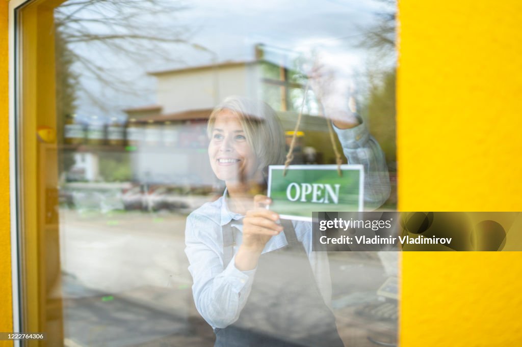 Colgar un cartel de apertura de una tienda