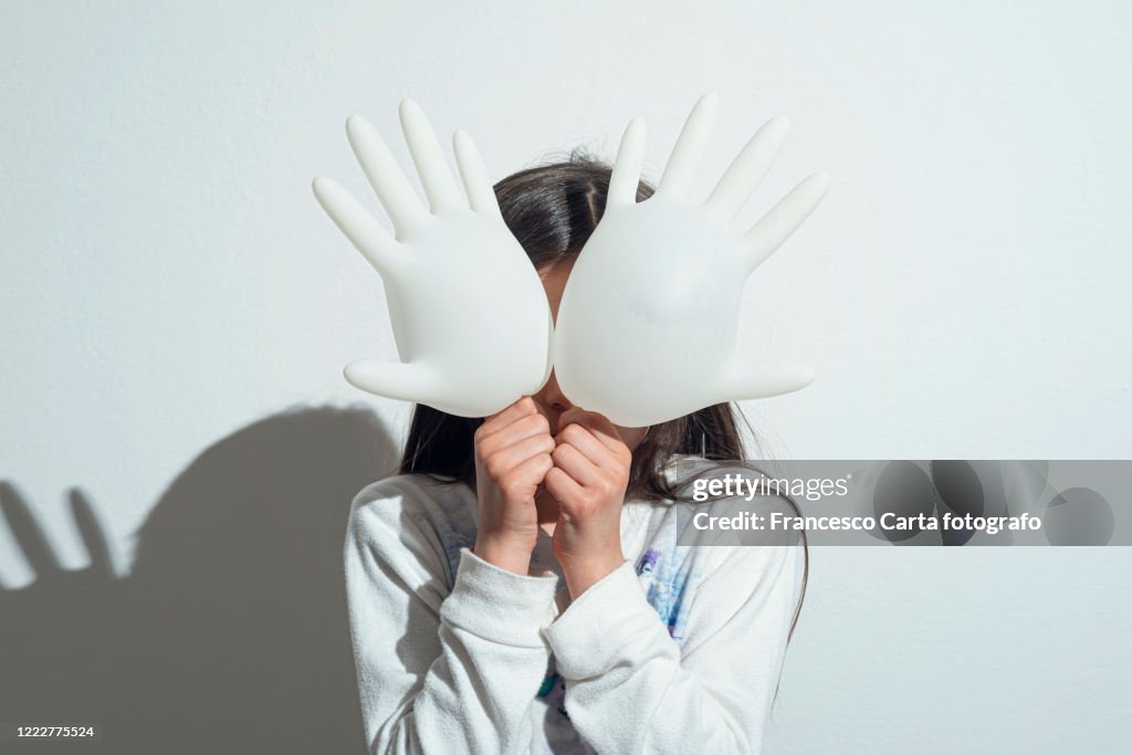 Girl playing with surgeon gloves inflated