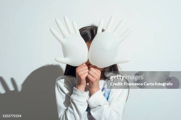girl playing with surgeon gloves inflated - surgical glove balloon stock pictures, royalty-free photos & images