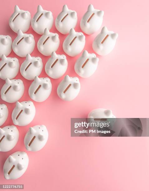 one piggy bank splitting from the crowd - achievement gap stock pictures, royalty-free photos & images