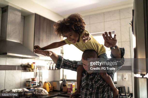 Father lifting excited happy little son at home