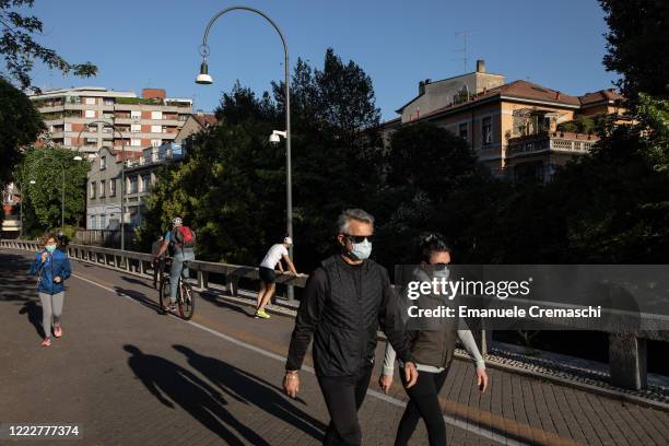 People wearing protective masks jog and run along the Naviglio Martesana canal on May 04, 2020 in Milan, Italy. Starting today, more than 4 millions...