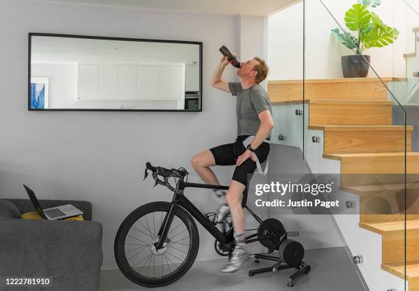 man on his turbo trainer at home. - exercise room stock pictures, royalty-free photos & images