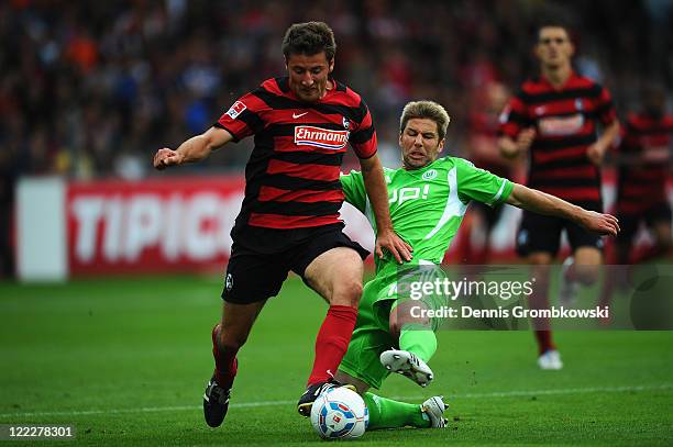 Stefan Reisinger of Freiburg is challenged by Thomas Hitzlsperger of Wolfsburg during the Bundesliga match between SC Freiburg and VfL Wolfsburg at...